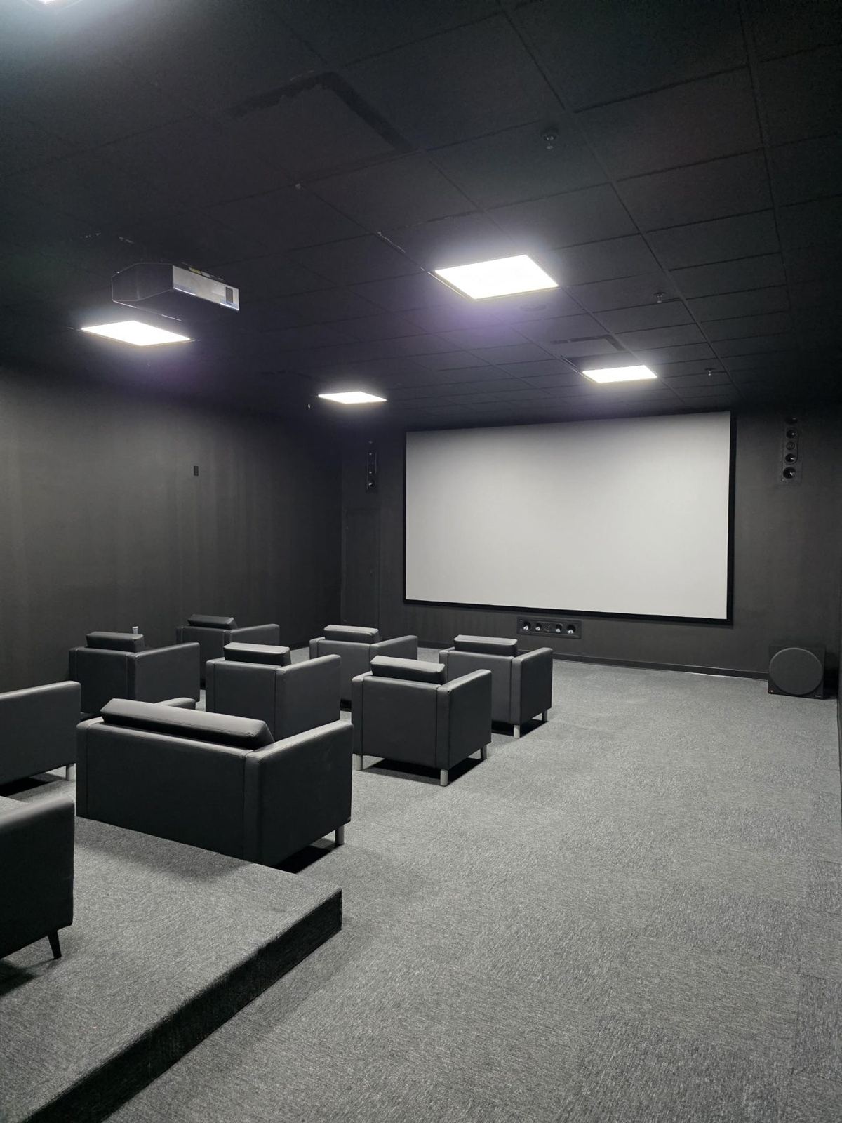 Dedicated home theater with projection screen and leather seating