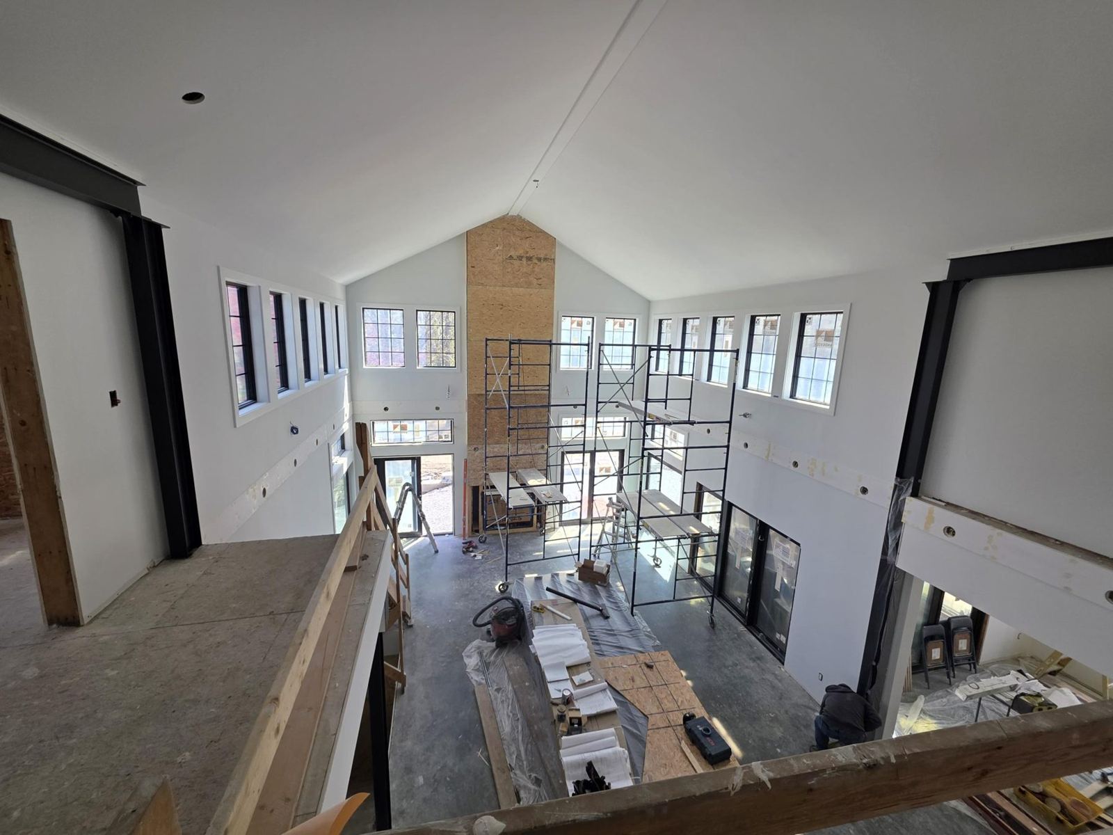 Drywalled vaulted room seen from the loft, finishes underway